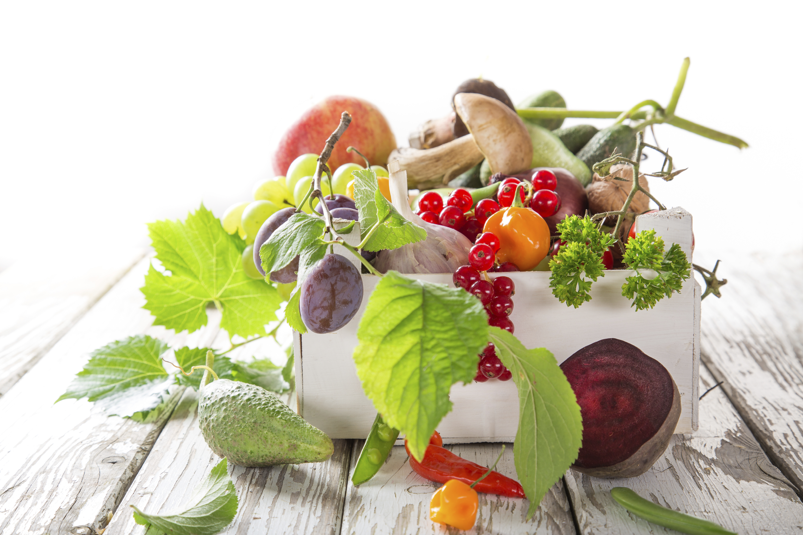 Masse forskjellige frukt og grønnsaker ligger på treunderlag.